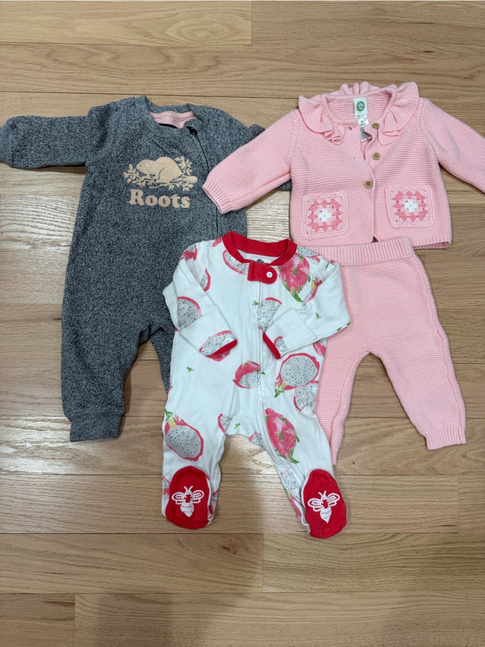 Three baby outfits: 3-6mo girls Roots onesie, cardigan outfit, dragonfruit footi
